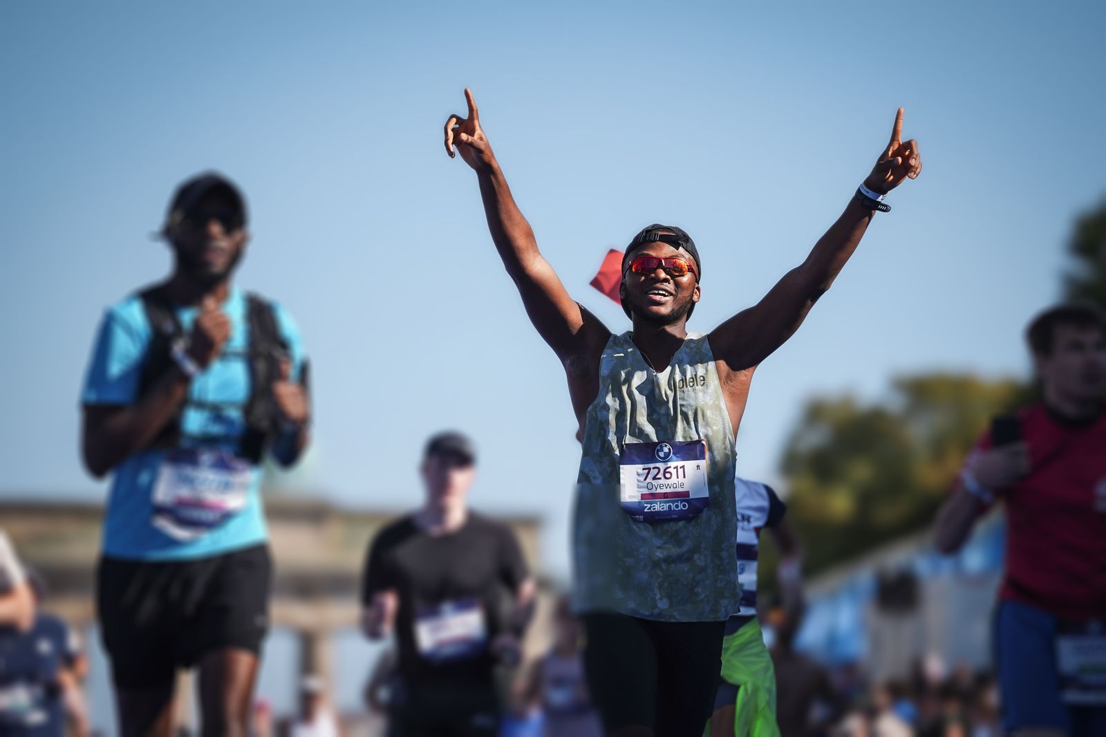 Oyewale with both arms raised in the finishing straight, Brandenburg Gate behind